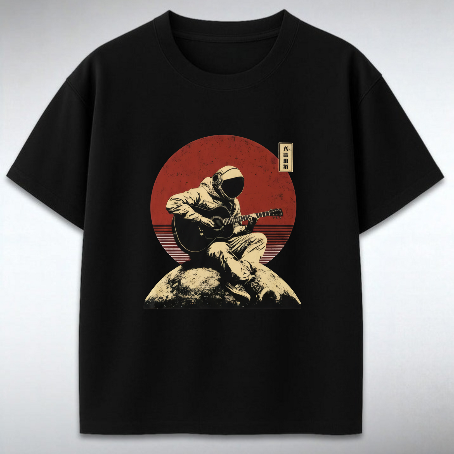 Black t-shirt with a graphic of a person playing guitar on a rock against a red sun backdrop.