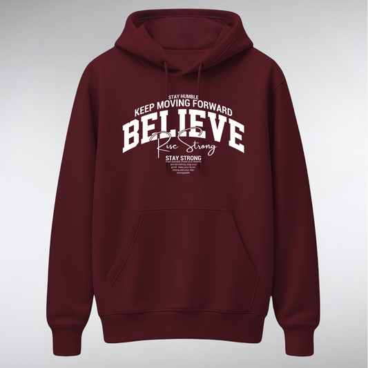 A heavyweight pullover hoodie featuring a collegiate-style chest graphic. The word "BELIEVE" is arched in large white serif letters, overlaid with "Rise Strong" in script, and surrounded by small text reading "KEEP MOVING FORWARD" and "STAY STRONG.